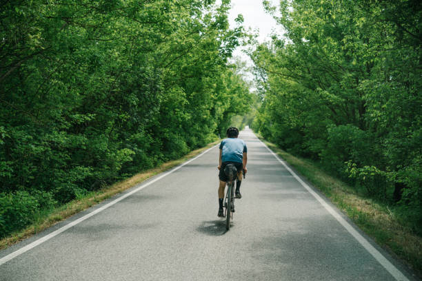 istock Young man rides bicycle through Tuscany countryside 1326339700