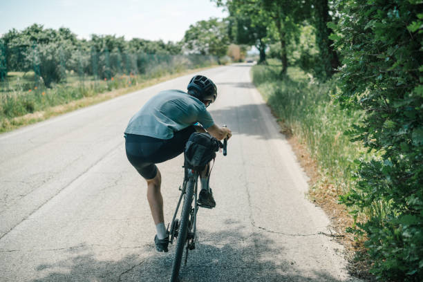 istock Young man has fun riding bicycle through Tuscany countryside 1326340938