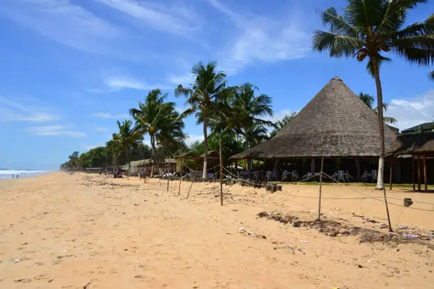 Grand-Bassam, Aboisso department, Sud-Comoé region, Comoé district, Ivory Coast / Côte d'Ivoire: long golden sand beach on the Atlantic Ocean - thatched roof restaurants.