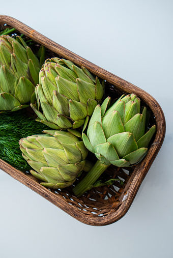 Artichoke in crate and green leaf vegetables on traditional green market stall in Bologna, Italy