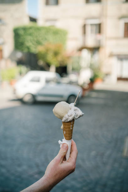 istock Hand holding ice-cream cone outdoors 1326341707