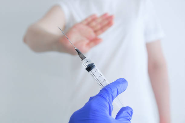istock Vaccination refusal concept. Syringe with vaccine in hand hand refusal gesture. 1326341965