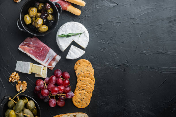 istock Italian snacks, meat cheese, herbs, on black background, flat lay  with copy space for text 1326343786