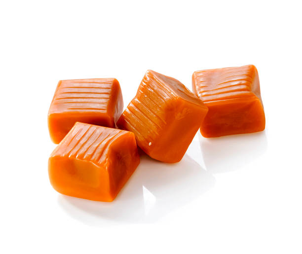 istock Four square pieces toffee caramel close-up isolated on white background 1326344314