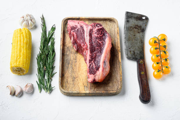 cooking meat background. raw aged beef t-bone steak, with spices and herbs for grill, on white stone  background - veal t bone steak raw steak imagens e fotografias de stock