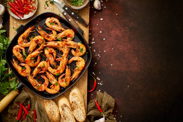 istock Tasty appetizing roasted shrimps prawns with spices on pan with ingredients on rusty background 1326348303
