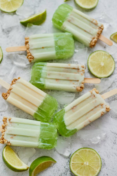 istock Lime and cream homemade popsicles or ice creams placed with ice cubes on gray stone backdrop 1326348326