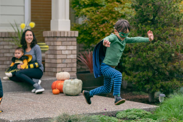 istock Boy in superhero costume jumping for joy on Halloween 1326358492