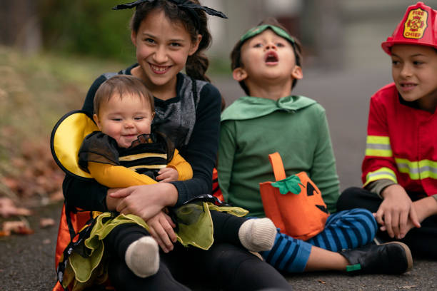 istock Mixed race siblings dressed in costumes on Halloween 1326358514
