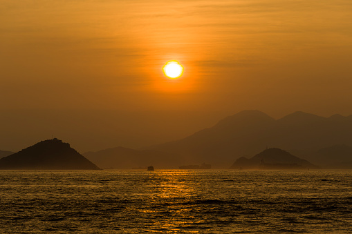 Sunset over the ocean. Scenic view of islands and hills during sunset. Eye Level View