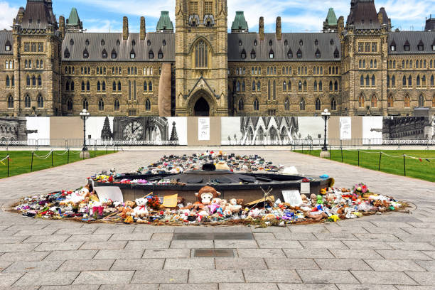 Items left in memory of indigenous children whose remains found on Residential School grounds in Canada Ottawa, Canada - June 30, 2021: The many shoes and toys left near the Centennial Flame on Parliament Hill in memory of the children whose remains were found near former Residential Schools. kamloops stock pictures, royalty-free photos & images