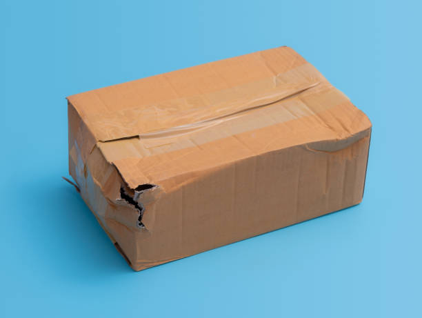 istock Damaged cardboard box with hole on blue background,cardboard box destroyed in shipping 1326364779