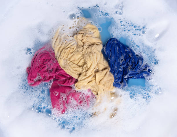istock Wet color clothes with white foam Soak before washing,top view 1326364788