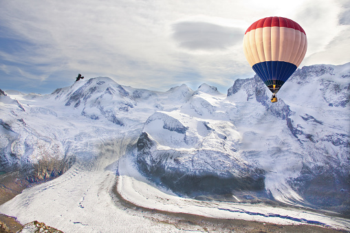 Scenic aerial view of red hot air balloon above the valley