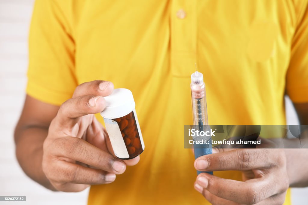 hand holding Insulin pens and pill container hand holding Insulin pens and pill container . Syringe Stock Photo
