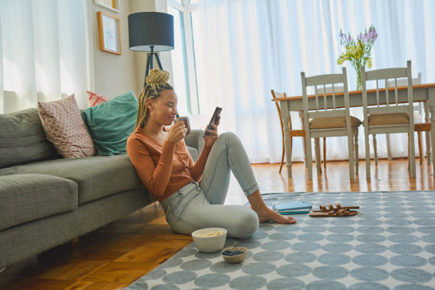 istock Shot of a young woman using a smartphone and having coffee while working from home 1326374992