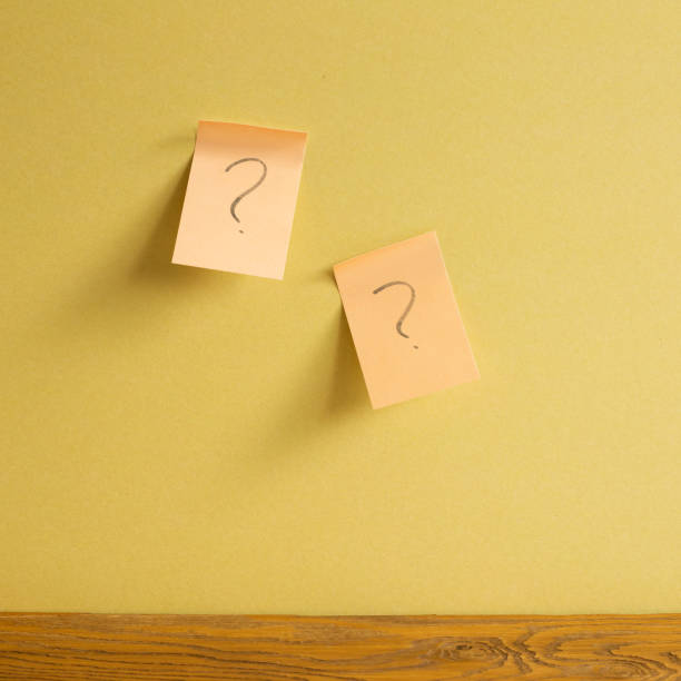 istock Sticky memo note paper with question mark on yellow wall. Thinking, solution, business, idea concept 1326375901