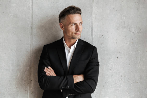istock Handsome man dressed in suit holding arms folded 1326381398