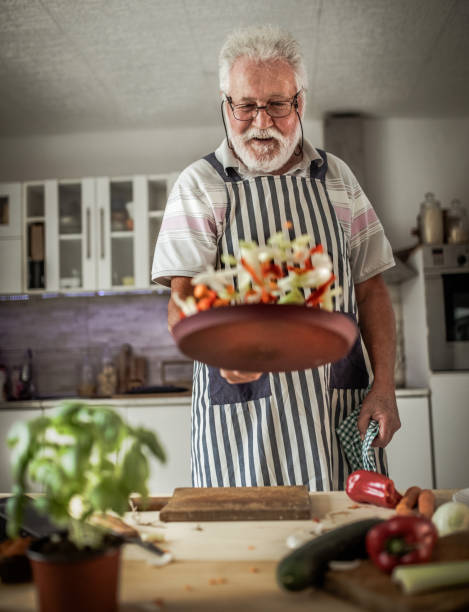 Senior man preparing delicious food in the kitchen