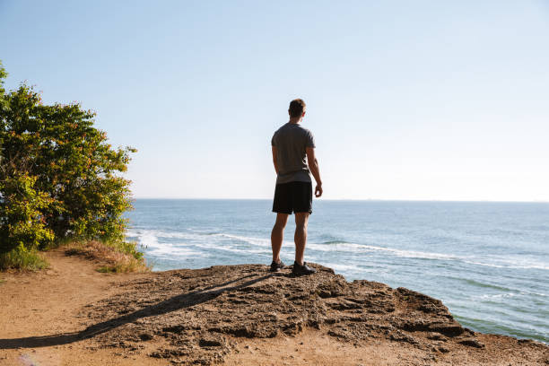 istock Young sportsman standing at the seashore and looking 1326387976