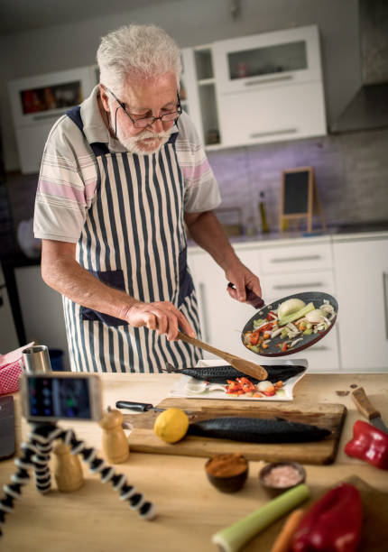 istock Senior man preparing fish in the kitchen 1326388809