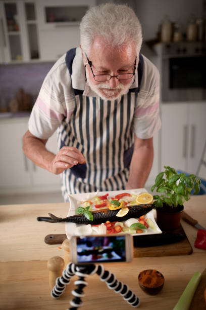 istock Senior man preparing fish in the kitchen 1326389400