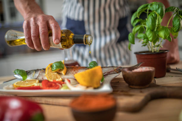 istock Senior man preparing fish in the kitchen 1326389454