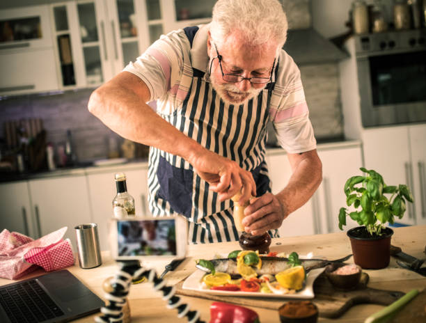 istock Senior man preparing fish in the kitchen 1326389470