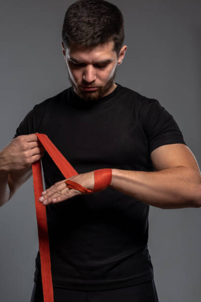 istock Young man wrapping hands with red cotton tape 1326389642
