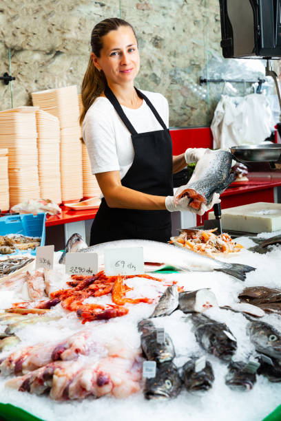 istock female fishmonger offering fresh chilled salmon for sale 1326391476