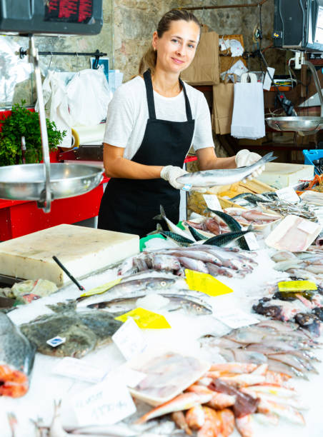 istock Female fishmonger offering sea bass 1326391502