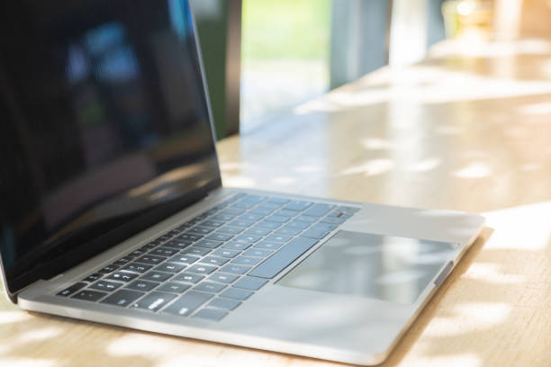 istock Selective focus with copy space of computer laptop or notebook on wooden table near window with beautiful sunlight in morning shows concept of work space from anywhere using internet technology. 1326392201