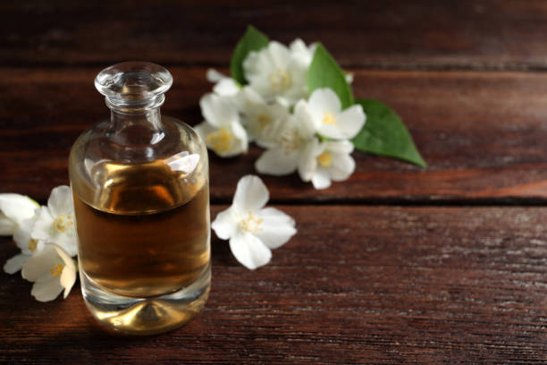 istock Essential oil and jasmine flowers on wooden table. Space for text 1326392425