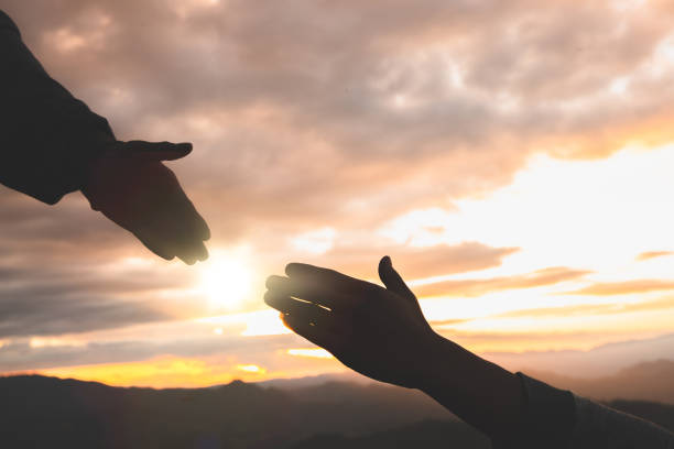 istock Silhouette of reaching, giving a helping hand, hope and support each other, hand help. 1326393582