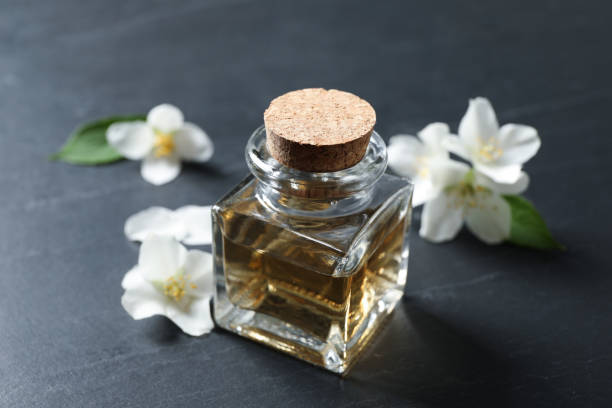 istock Jasmine essential oil and fresh flowers on dark grey table 1326394016