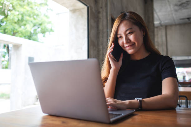 istock A businesswoman using mobile phone and working on laptop computer in office 1326394159