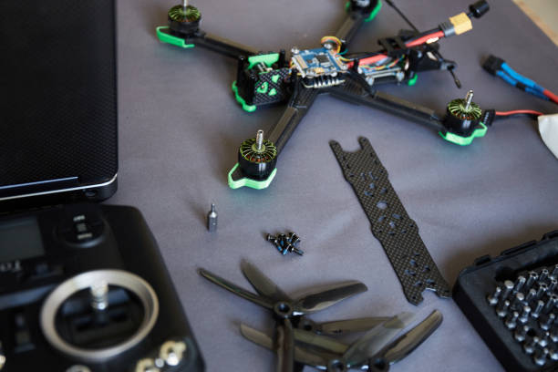Close up of man's hands assembling a drone from parts, using tools, Preparing high-speed racing quadcopter for flight. Repair drone before training process.