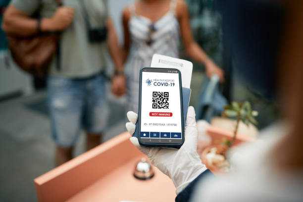 istock Close-up of non immune COVID-19 vaccination certificate on mobile app during guests check-in a hotel. 1326398607