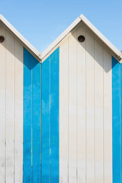 Colorful wooden beach huts and summer blue sky, vacations concept