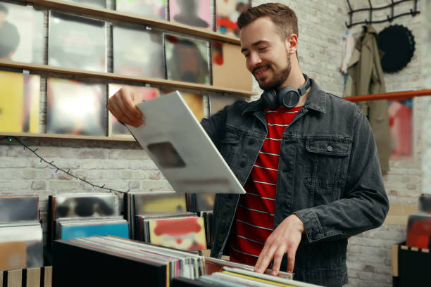 istock Young man with vinyl record in store 1326401115