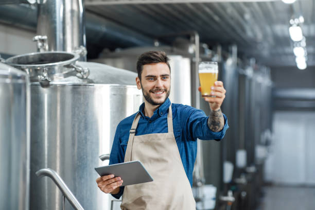 quality control of alcoholic beverage in production and work in brewery inspecting quality of production at factory - action alcohol alcoholism bar imagens e fotografias de stock