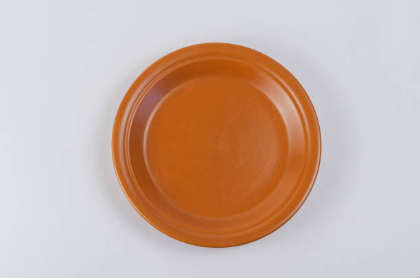 istock Brown round clay plate on white background. Kitchen utensils mad 1326403332