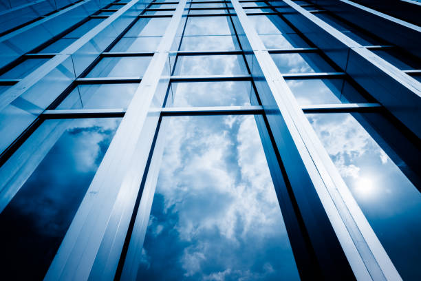 istock Blue sky and clouds reflected at glass wall 1326404729