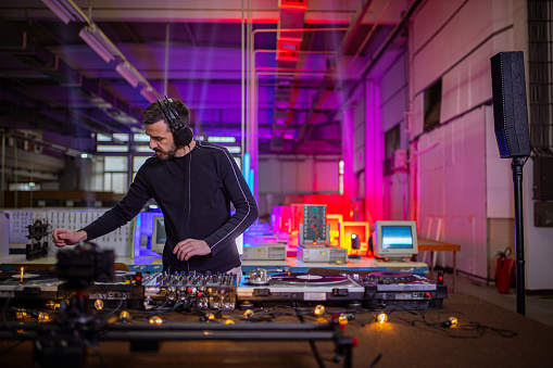 In the alternative hangar, modern and urban male DJ, live broadcasting his music set, so the people from their homes can enjoy funky music