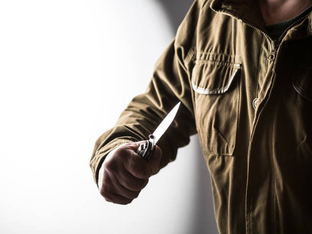 istock Man holding a knife in a threatening stance 1326407214