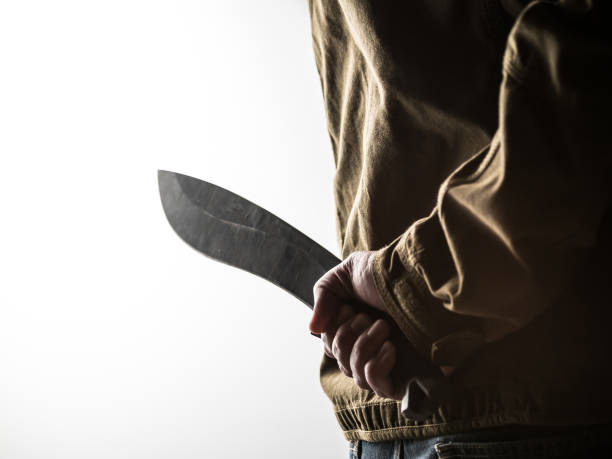 istock Man holding a machete behind his back 1326407339