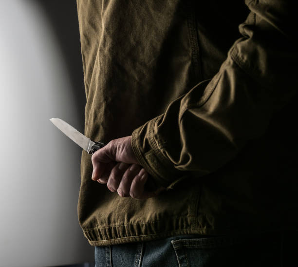 istock Man holding a knife behind his back 1326407368