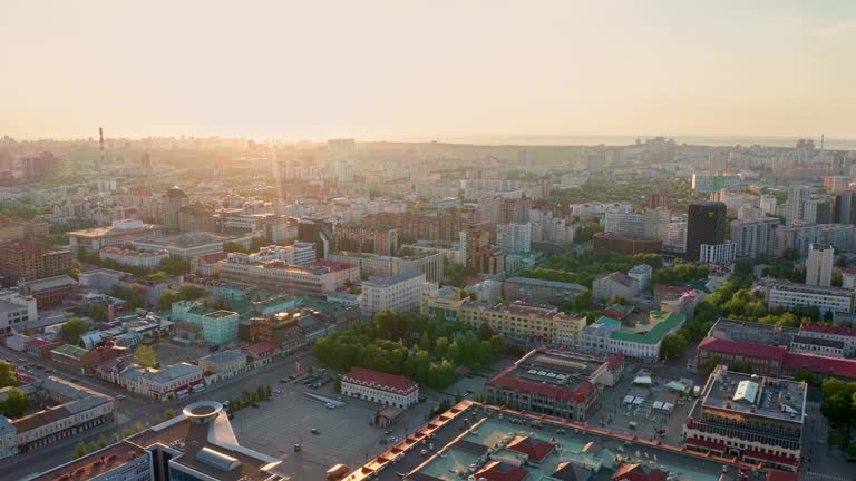 Sunset on the horizon. View of the multi-colored roofs of high-rise buildings. Dense urban development, business center. Public places, urban environment.