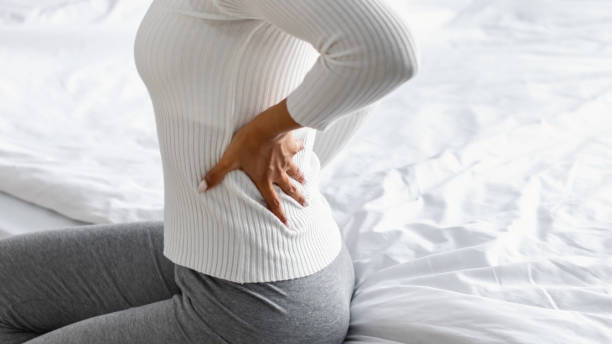 침대에 앉아 허리 통증과 흑인 여성의 클로즈업 - 허리통증 뉴스 사진 이미지