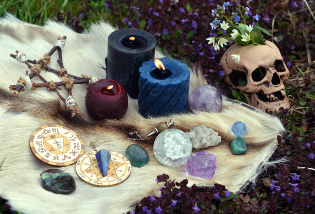 istock Beltane still life with ritual objects, skull, burning candles, pentagram and crystals outside. 1326410142